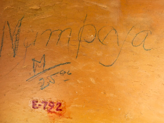 detail of E-792 showing Nampeyo's name written in pencil, along with “M 25.00,” on the side of the jar near the base