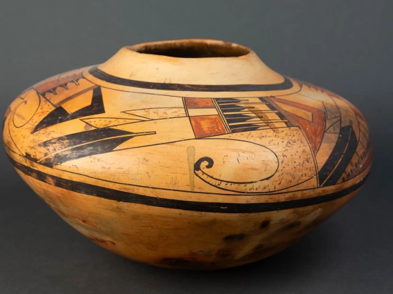 A large Hopi jar with polychrome designs painted on a field of yellow clay.