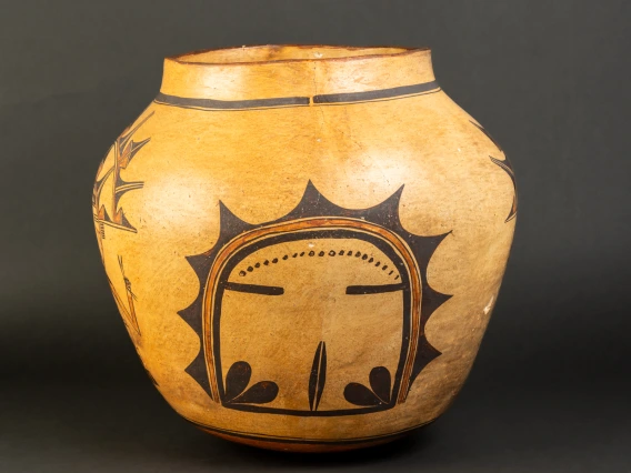 A large Hopi jar with polychrome katsina design painted on a field of yellow clay.