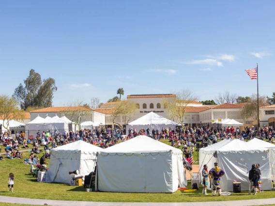 white tents and a lot of people on a green lawn