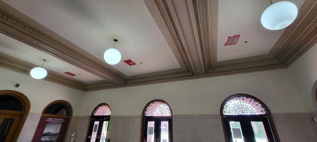 holes covered with plastic and red tape in the ceiling of the lobby