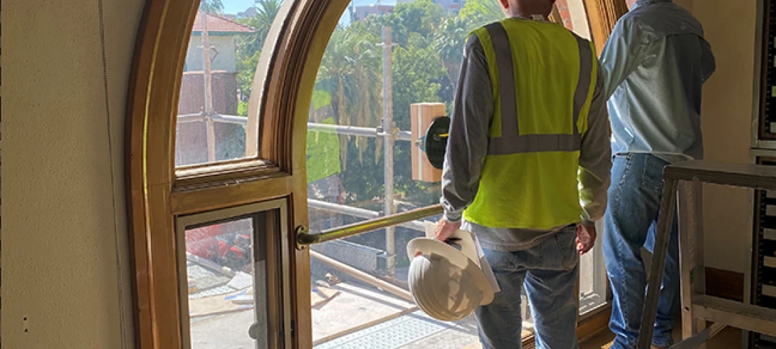 contractors inspecting windows from inside the building