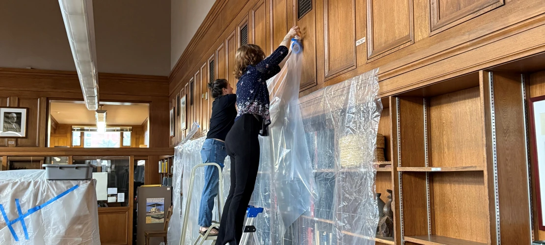 conservators cover library collections with plastic sheeting when flood is discovered