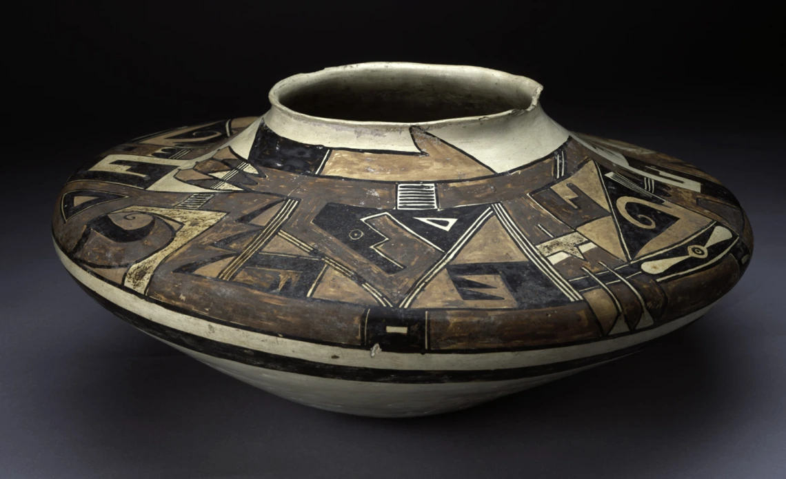 An ancient Hopi ceramic vessel with low shoulders. Polychrome painted designs on yellow clay.