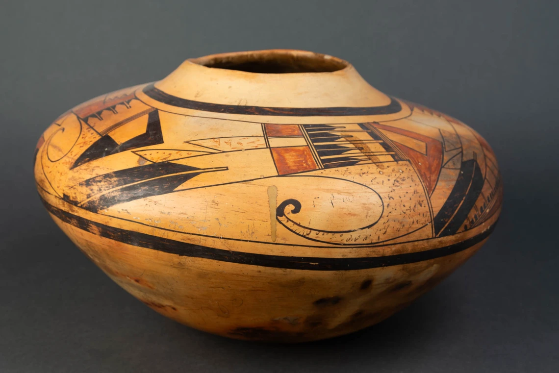 A large Hopi jar with polychrome designs painted on a field of yellow clay.