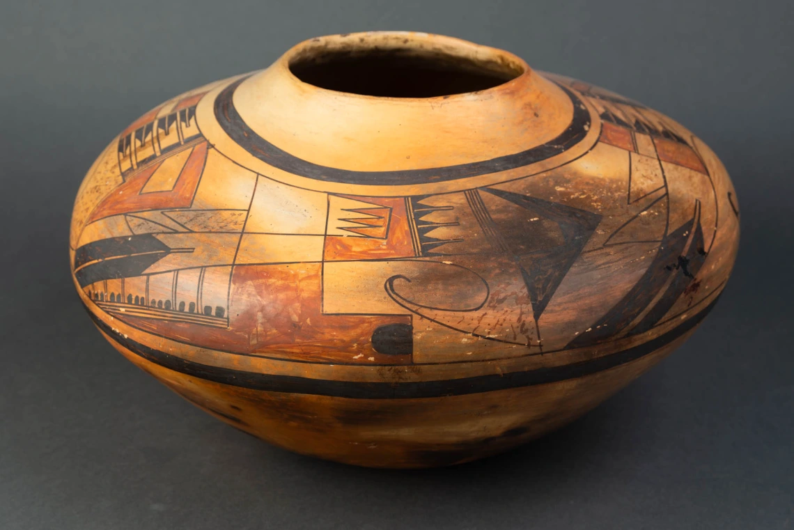 A large Hopi jar with polychrome designs painted on a field of yellow clay.