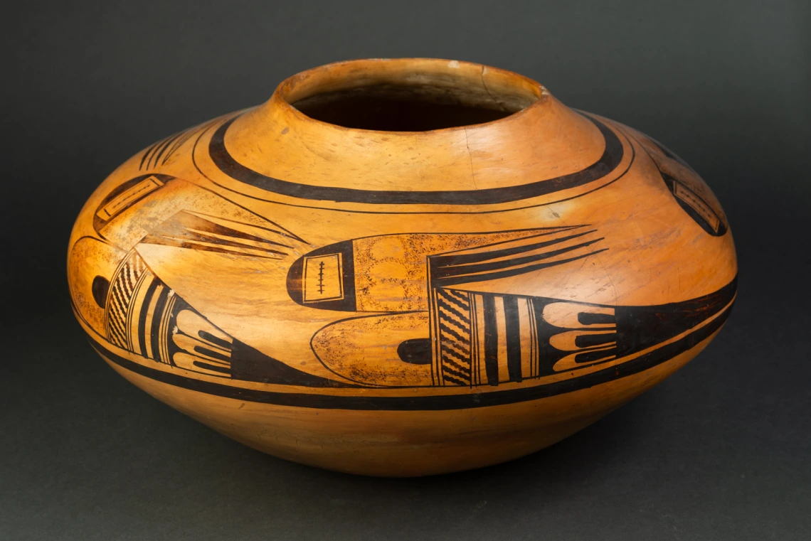 A large Hopi jar with polychrome designs painted on a field of yellow clay.