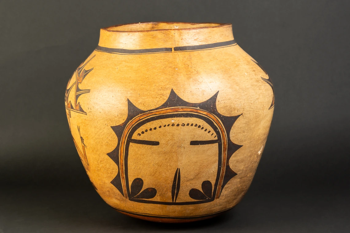 A large Hopi jar with polychrome katsina design painted on a field of yellow clay.