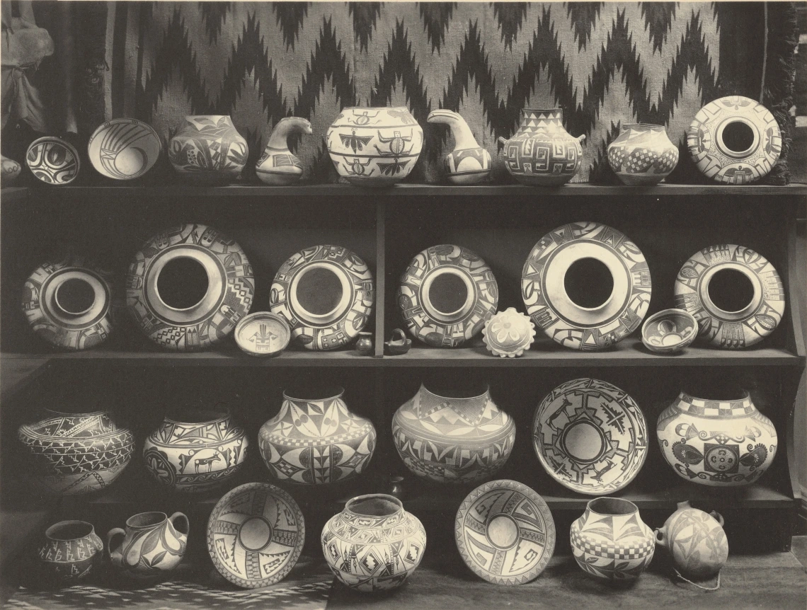 black and white photos showing rows of Hopi pottery lined up on shelves and on the floor