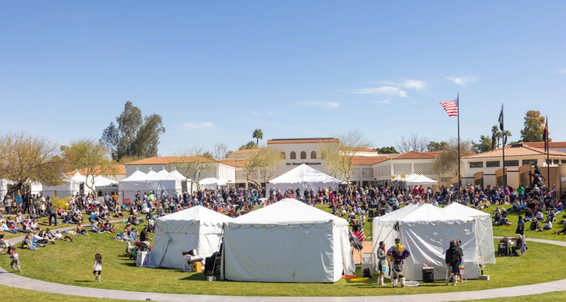 white tents and a lot of people on a green lawn