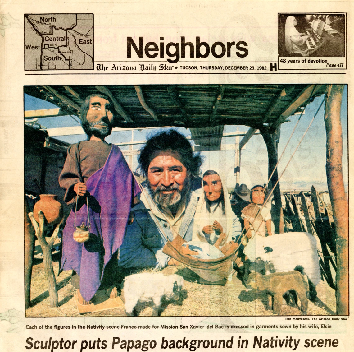 newspaper clipping showing photo of a man amind carved wooden figures he made