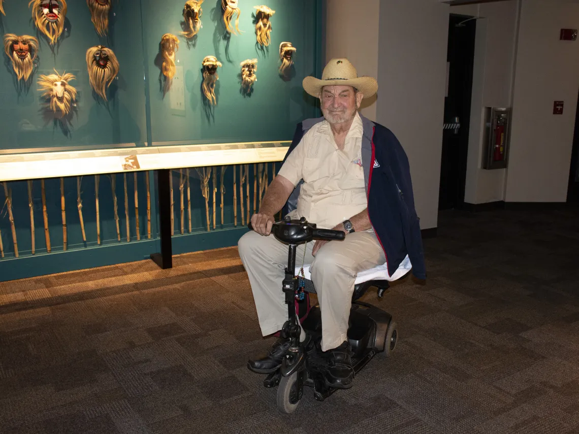 Dr. James S. Griffith in front of wall of masks