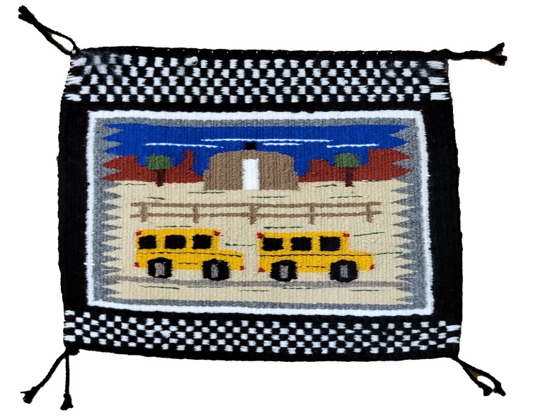 Pictorial Navajo rug showing 2 yellow school buses in the foreground and a hogan in the background.