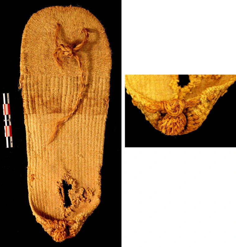 The sandal has a round toe and a puckered heel. The top of the sandal has a stripe with a faint geometric design.