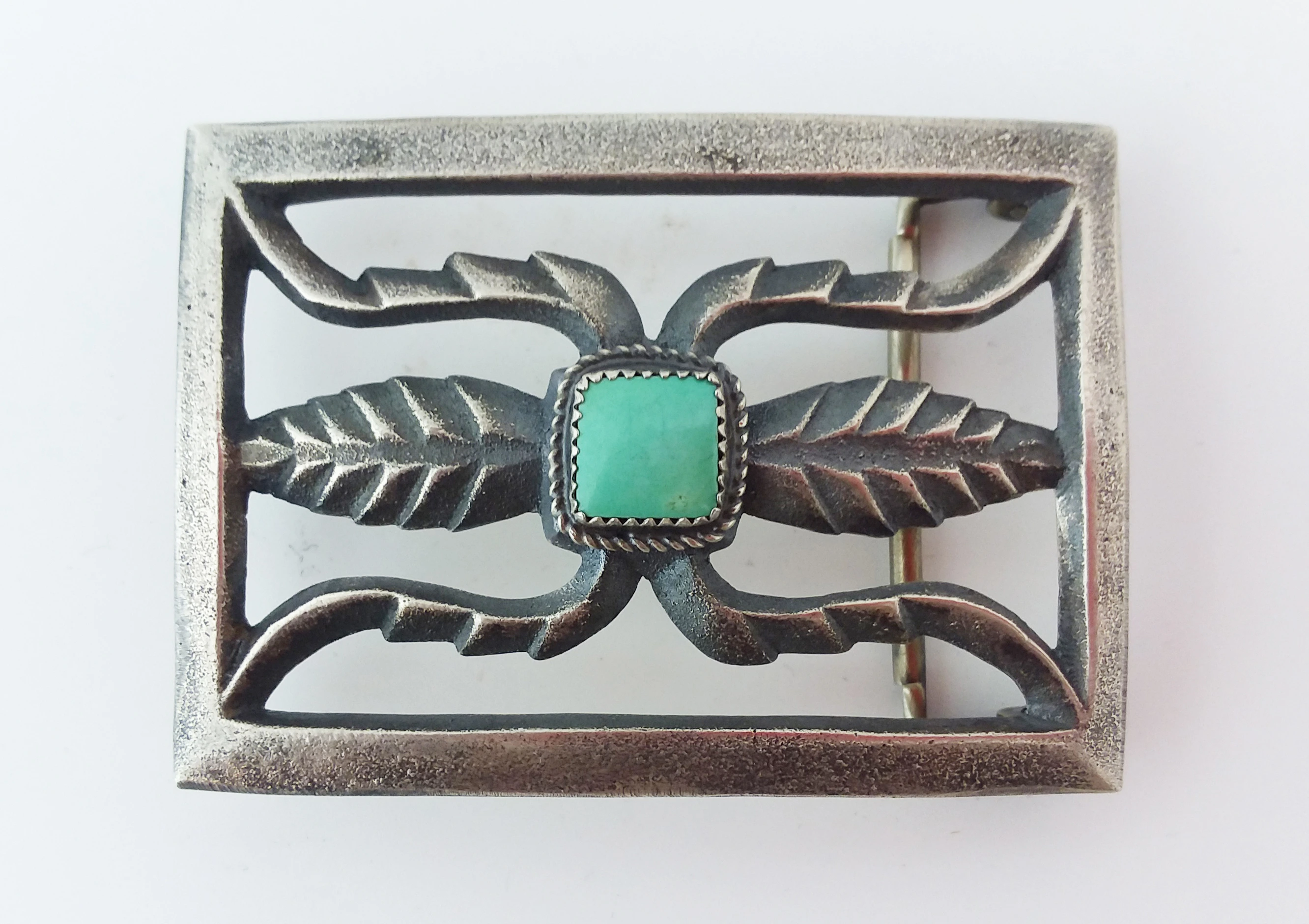 silver belt buckle with turquoise in center