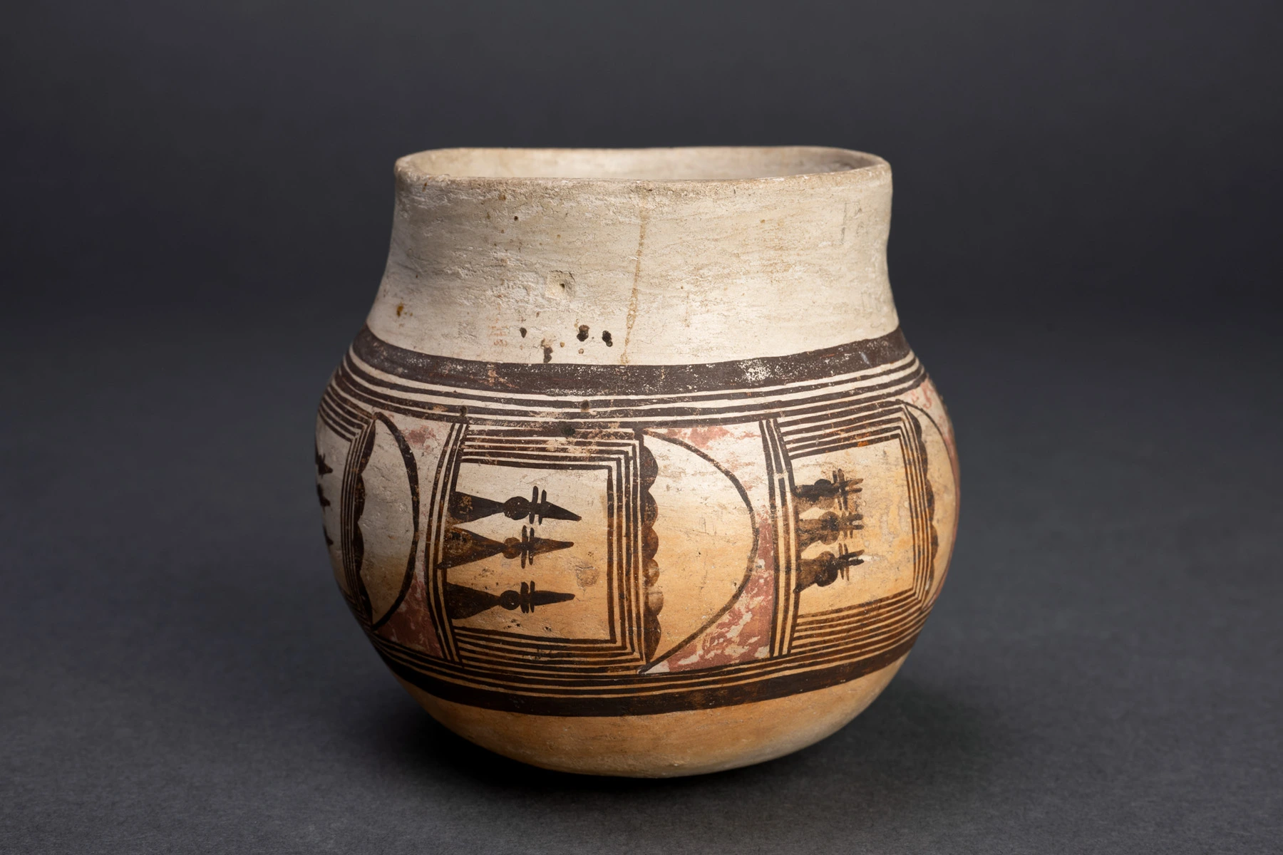 A small Hopi jar, black and red paint on yellow clay.