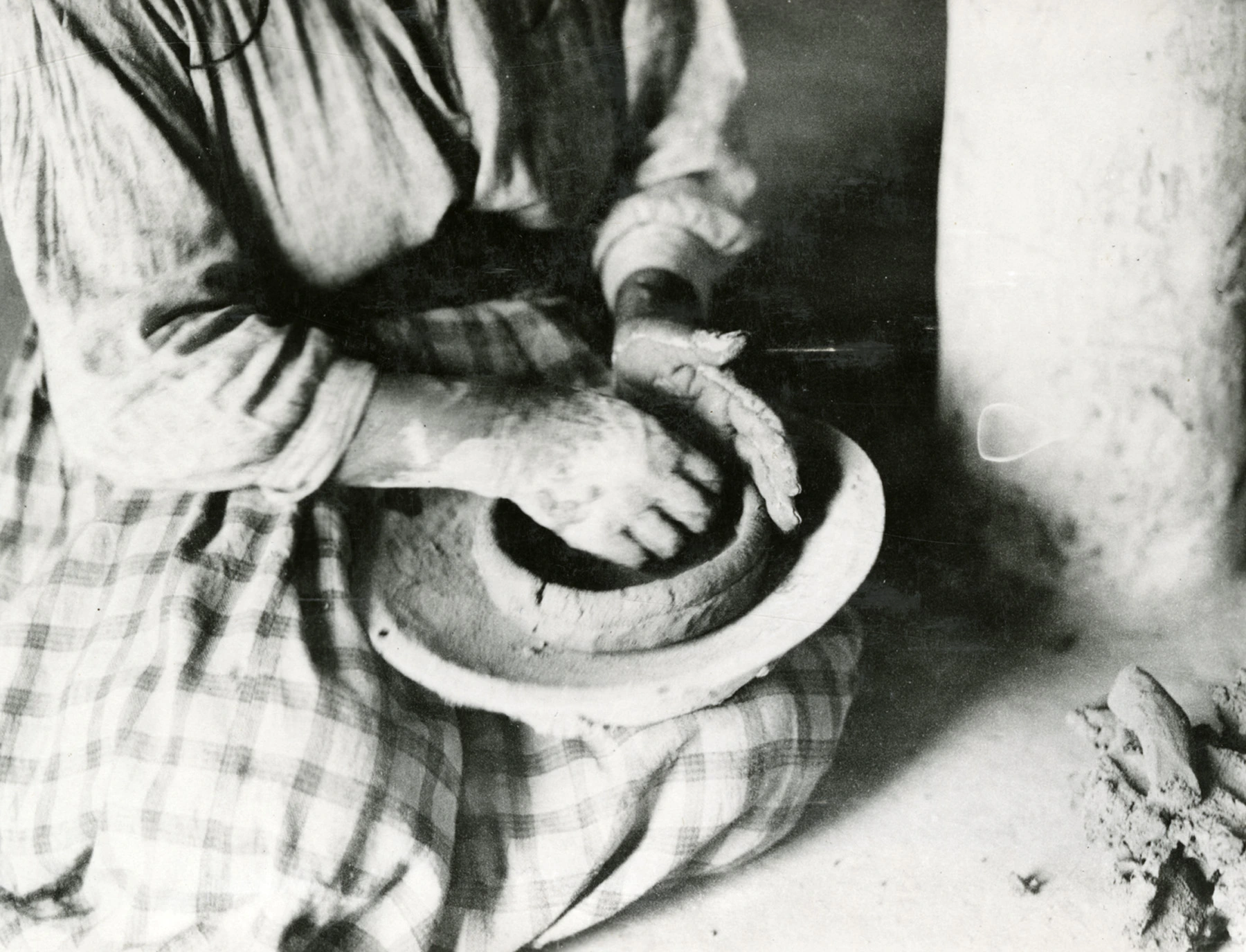 a woman is hand building a bowl using the coil-and-scrape method