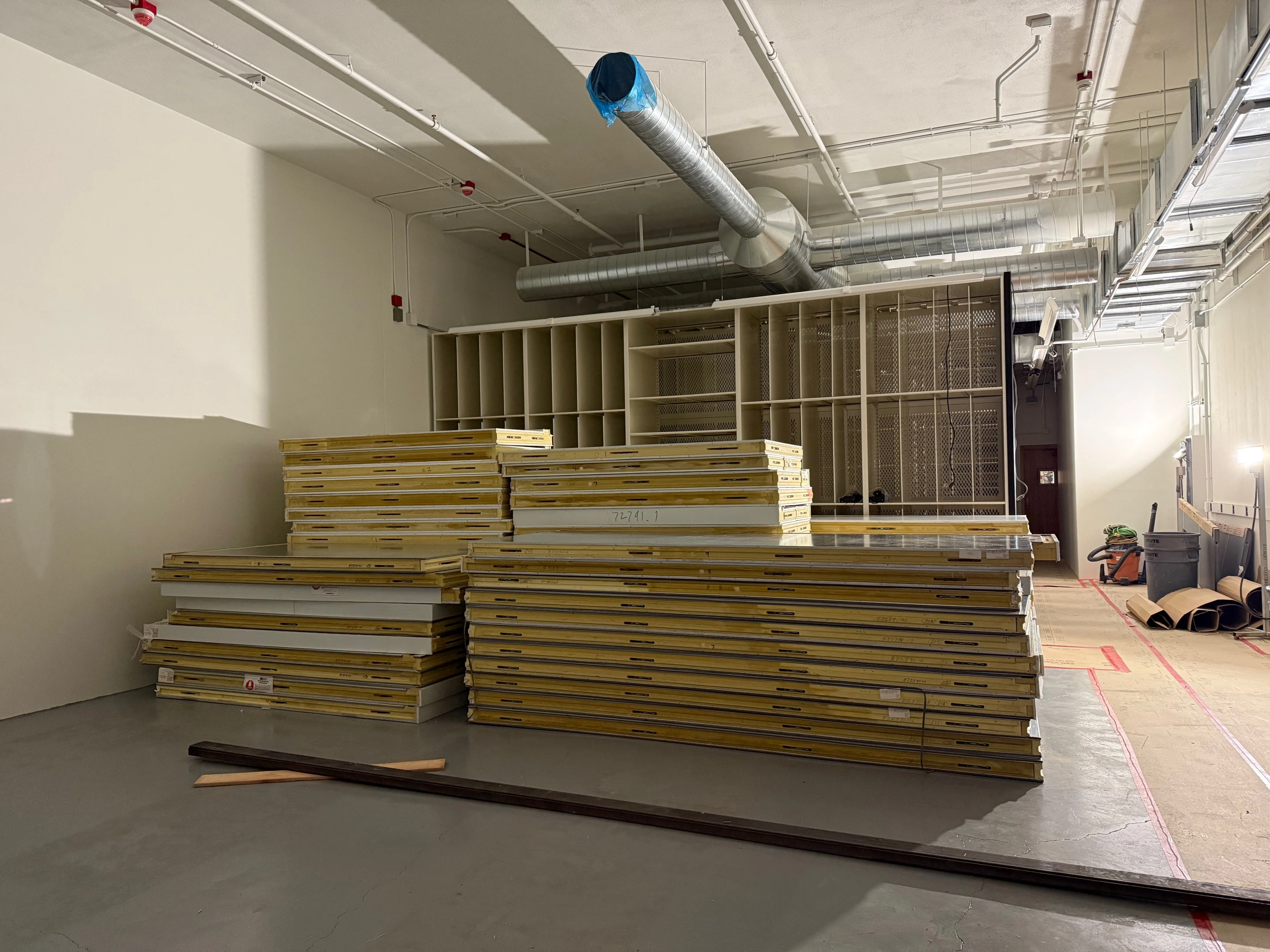 a view of a room under construction with compactor shelving units being installed